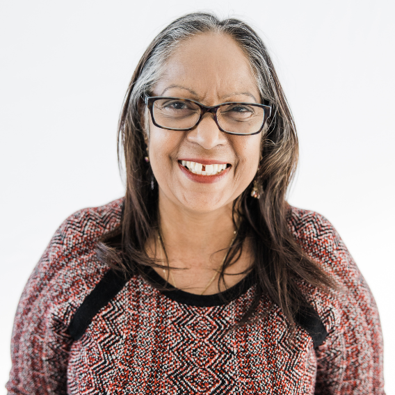 Woman with glasses wearing a red and black top.